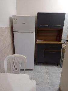 马卡埃Residencial Barbosa - Apto 102的厨房配有白色冰箱、桌子和椅子