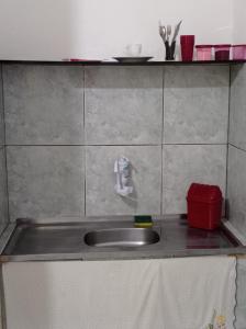 马卡埃Residencial Barbosa 103的一个带水槽和红色容器的厨房台