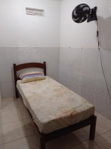 马卡埃Residencial Barbosa 103的配有风扇的客房内的一张小床