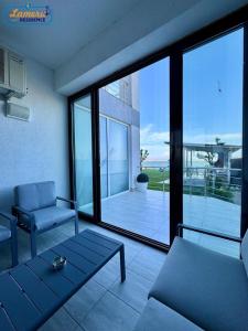 马马亚Lamera Residence Mamaia Apartments的带沙发和玻璃窗的客厅