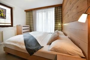 塔查斯卡-鲁穆尼卡APLEND Hotel Kukučka的一间卧室配有一张带木制床头板的床