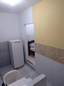 马卡埃Residencial Barbosa - Apto 102的一间小房间,配有冰箱和一张床