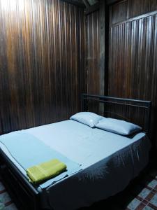 丰盛港Warisan Homestay Anjung的木墙客房的一张床位