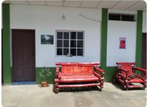 马那瓜31 ave home stay的两个红色长椅坐在大楼前