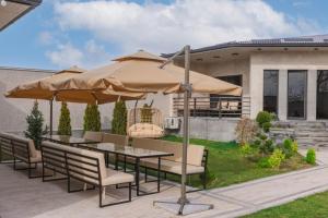 阿尔兹尼Chic Villa with many amenities, one of a kind in the country的庭院配有桌椅和遮阳伞。