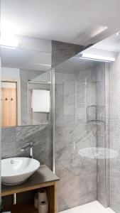 普雷达佐Hotel La Montanara Predazzo的一间带水槽和玻璃淋浴的浴室