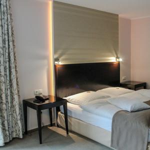 Girod弗雷穆尔餐厅酒店的一间卧室配有一张大床和一张桌子