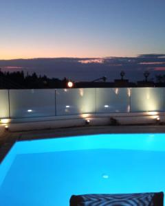 苏卡雷斯Goudis Villas的享有阳台的景色,晚上有蓝色的灯光