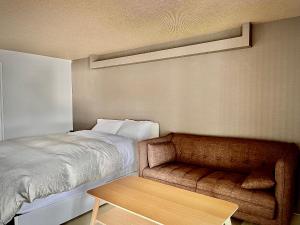 小樽Stay`sOTARU的一间卧室配有一张床、一张沙发和一张桌子