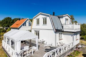 卡尔斯克鲁纳Nice house with a panoramic view of the sea on beautiful Hasslo outside Karlskrona的白色的房子,设有门廊和甲板
