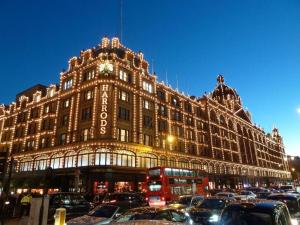 伦敦(Kensington-Olympia-Museums ) Apartment Central London的一座大型建筑,前面有汽车停放