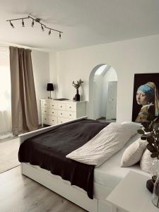 埃姆登Ferienwohnung Altstadtblick的白色卧室设有一张大床和一个梳妆台