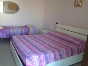 苏尔博B&B La Stella的一间卧室配有两张床和条纹床罩