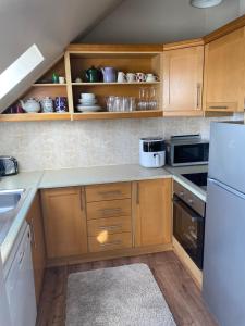 拉辛赫Lahinch Central 3-Bed Retreat的厨房配有木制橱柜和白色冰箱。