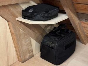 滨海利翁LES BRIQUES的两个黑包坐在房间里的一个架子上
