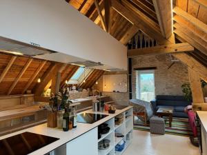 滨海利翁LES BRIQUES的一间带木制天花板的厨房和一间客厅