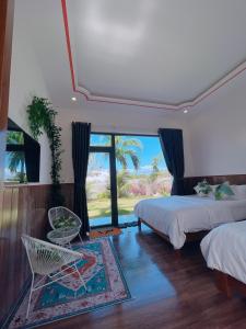 Phú HiệpLàng biển HomeStay Phú Yên的一间卧室设有两张床、一把椅子和一个窗户。