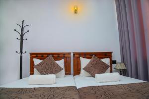 康提Kandy Tower Inn的一间卧室配有两张带棕色和白色枕头的床