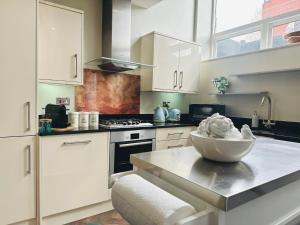 伦敦Stylish, modern appartment in Central London的厨房配有白色橱柜和碗盘