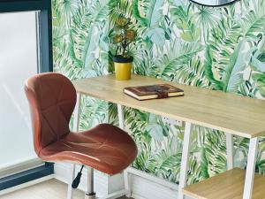 伦敦Stylish, modern appartment in Central London的一张椅子,坐在桌子旁,贴着壁纸