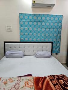 瓦拉纳西Goroomgo Gautam Garden Varanasi - Best Location & Parking Facilities的卧室配有白色床和蓝色墙壁
