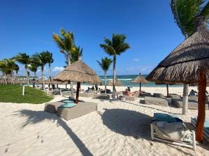 艾库玛尔Big 5BR Home for an epic time in Riviera Maya的海滩上设有椅子和遮阳伞,还有大海