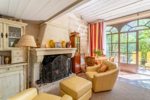 圣雷米普罗旺斯L'orangerie的客厅设有壁炉和黄色椅子