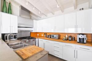 马里布The Surfrider Villa - Malibu Road - MOKE Electric Car Included的厨房配有白色橱柜和水槽