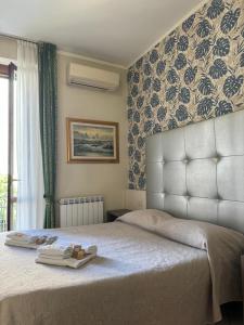 米兰利昆尔齐酒店的一间卧室配有一张床,上面有两条毛巾