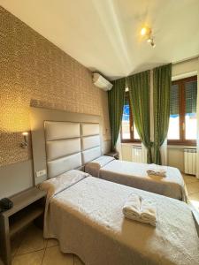 米兰利昆尔齐酒店的酒店客房设有两张床和窗户。