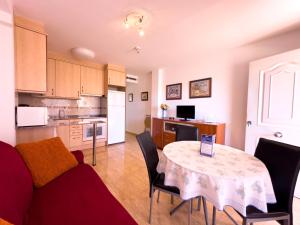蒙特罗伊Acogedor apartamento cerca de la playa wifi y parking的厨房以及带桌椅的起居室。