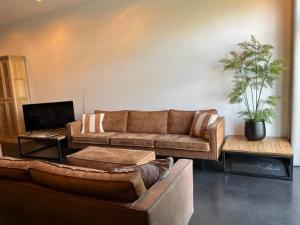 巴勒纳绍La Petite Fleur的带沙发和电视的客厅