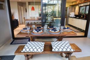 朱奎Condomínio Quinta de Juquehy - Prime Experience的一张木桌,上面有盘子和玻璃杯
