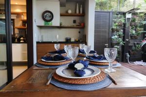 朱奎Condomínio Quinta de Juquehy - Prime Experience的一张木桌,上面放有盘子和酒杯