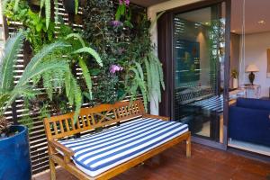 朱奎Condomínio Quinta de Juquehy - Prime Experience的木凳坐在种满植物的门廊上