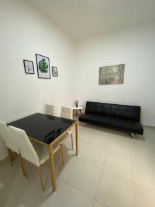 布卡拉曼加Sachar Lodging Apartahotel的客厅配有黑色沙发和桌子