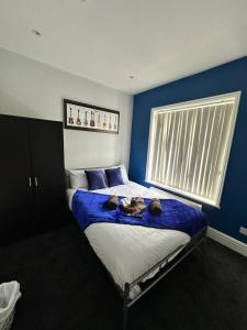 利物浦Quirky Oasis Queens的一间卧室配有一张蓝色墙壁的床和一扇窗户