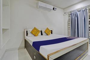 KharkaOYO Amer Inn的一间卧室配有黄色和蓝色枕头的床