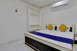 KharkaOYO Amer Inn的一间卧室配有蓝色和黄色枕头的床