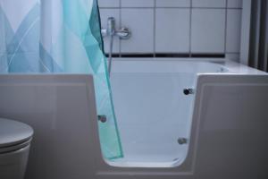 维利希ruhiges Gästezimmer in Messenähe的带浴缸、卫生间和淋浴的浴室。