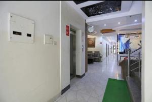 新德里HOTEL AIRPORT INN near Delhi Airport的客厅配有沙发和墙上的时钟