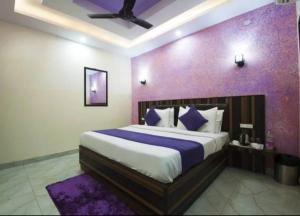 新德里HOTEL AIRPORT INN near Delhi Airport的一间卧室配有一张大床和紫色墙壁