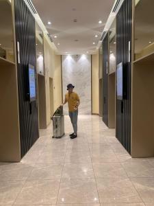 吉隆坡Klcc Suites at Axon By Skypool的站在走廊上,有垃圾桶的人