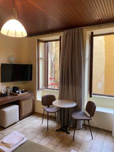 干尼亚海伦娜酒店的客房设有桌子、两把椅子和窗户。