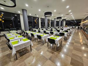 克雷尼察Silesia Krynica的一间设有白色桌椅的大型用餐室
