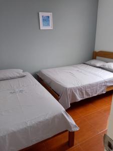 卢林Habitaciones Matrimoniales en Playa Pulpos HOSPEDAJE DELFINES HOUSE的两张睡床彼此相邻,位于一个房间里