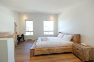 BrownsburgChalet Élios的一间卧室设有木床和2个窗户。