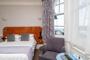 布莱顿霍夫莱恩斯酒店的卧室配有床、椅子和窗户。