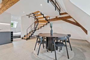 卢森堡Escape to Clausen Stylish Apartment ID212的一间带桌子和楼梯的用餐室