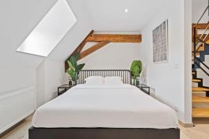卢森堡Escape to Clausen Stylish Apartment ID212的一间带白色床的卧室,位于带楼梯的房间